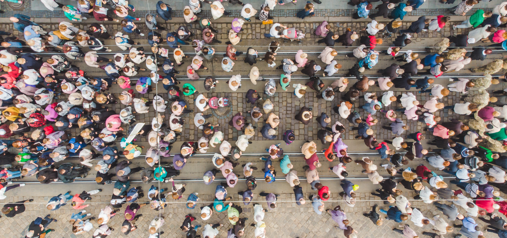 An aerial view of many people walking along a street.