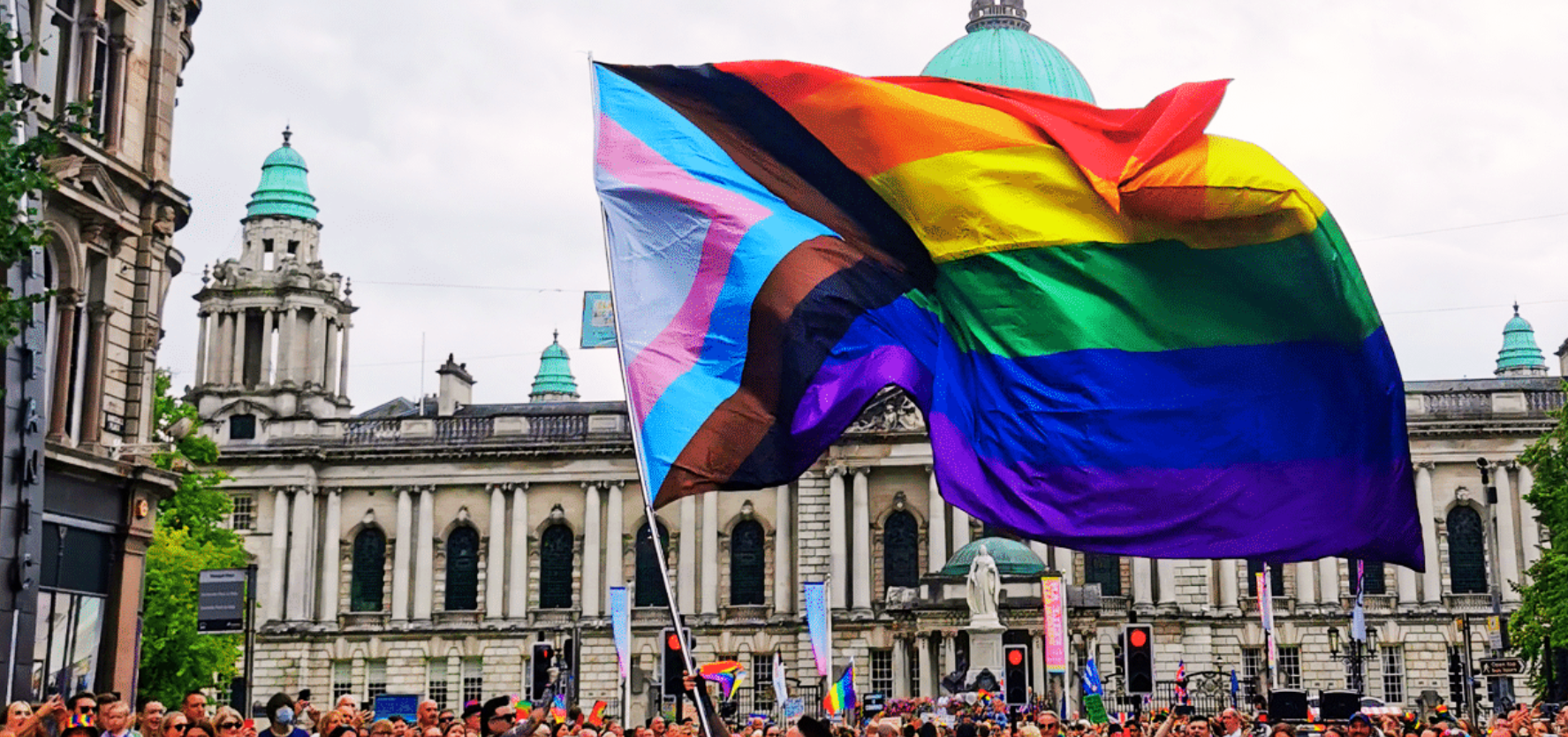 A member of the Rainbow Project waves a progress pride flag in front of City Hall during Belfast Pride. Picture: Rainbow Project